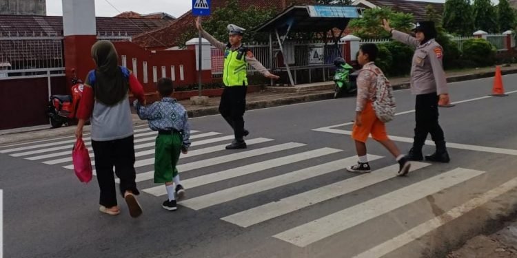 Peduli Keselamatan, Personel Polres Pandeglang Bantu Sebrangkan Anak Sekolah