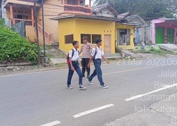 Peduli Keselamatan Personel polsek Bayah Polres Lebak Bantu Sebrangkan Anak Sekolah
