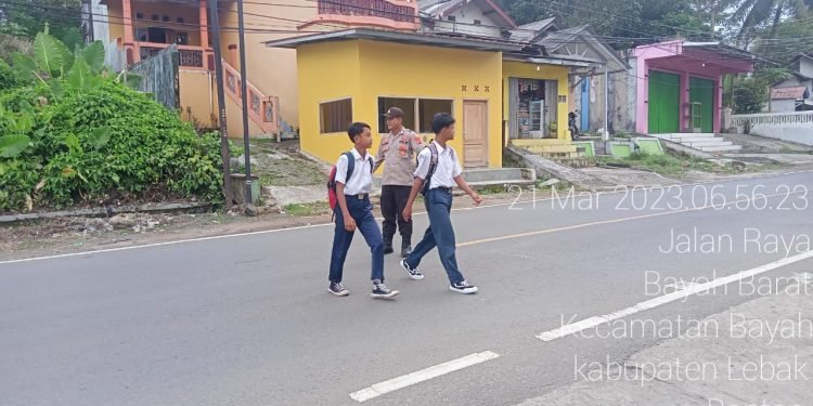 Peduli Keselamatan Personel polsek Bayah Polres Lebak Bantu Sebrangkan Anak Sekolah