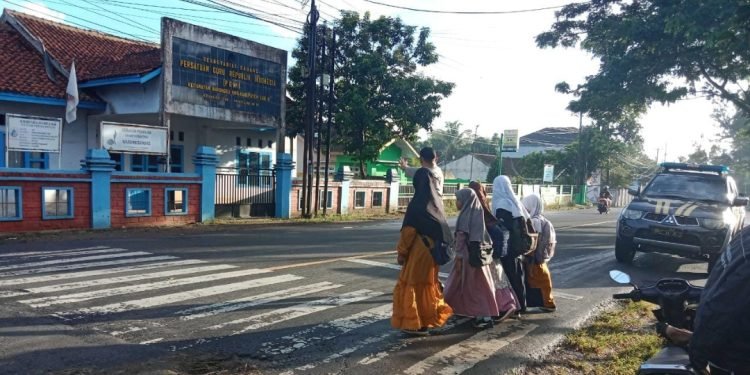 Menjaga Kamtibmas,Personil Polsek Warunggunung Polres Lebak Menyebrangkan Anak sekolah strong point di SDN Selaraja