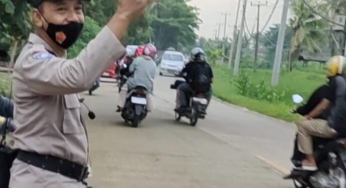 Anggota Polsek Panggarangan Polres Lebak Giat Gatur Lalulintas  Di Depan Pintu Masuk Wisata Pantai Pasir Putih