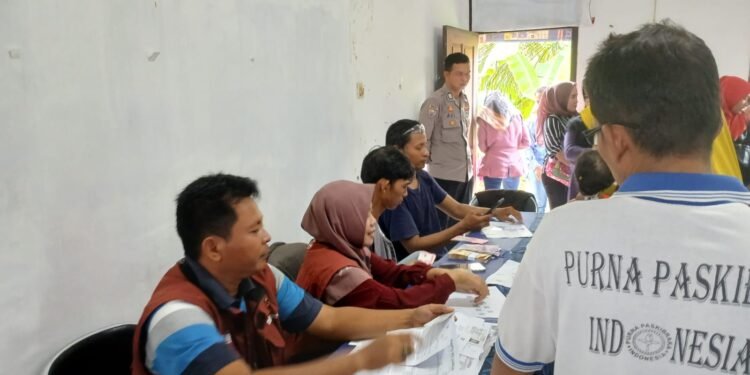 Bhabinkamtibmas Polsek Cimarga Polres Lebak Monitoring dan Pengamanan Pembagian Bansos BPNT dan PKH Kepada 325 KPM Di Desa Mekarjaya Cimarga