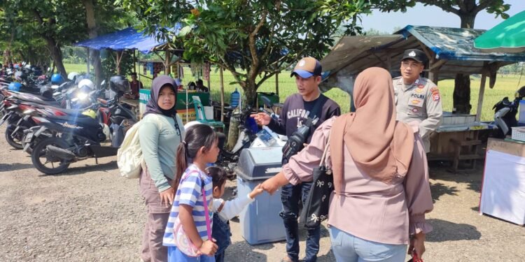 Anggota Polsek Rangkasbitung Polres Lebak Sapa  Pengunjung Yang Akan Masuk Ke Kolam Renang Bim